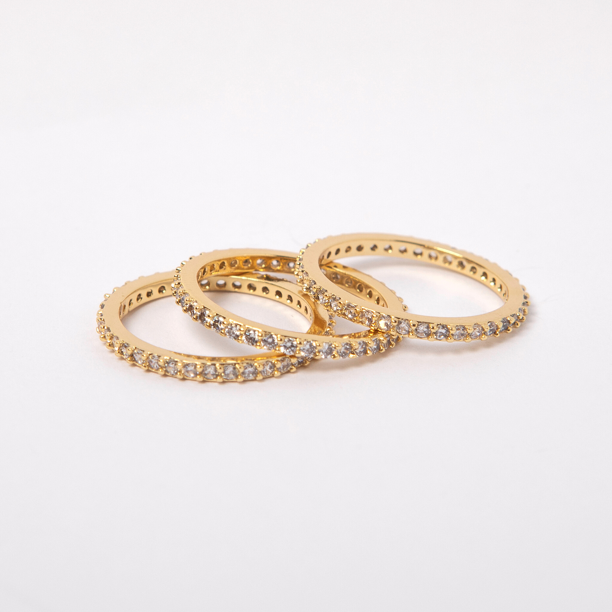 3 Crystal accented gold eternity rings