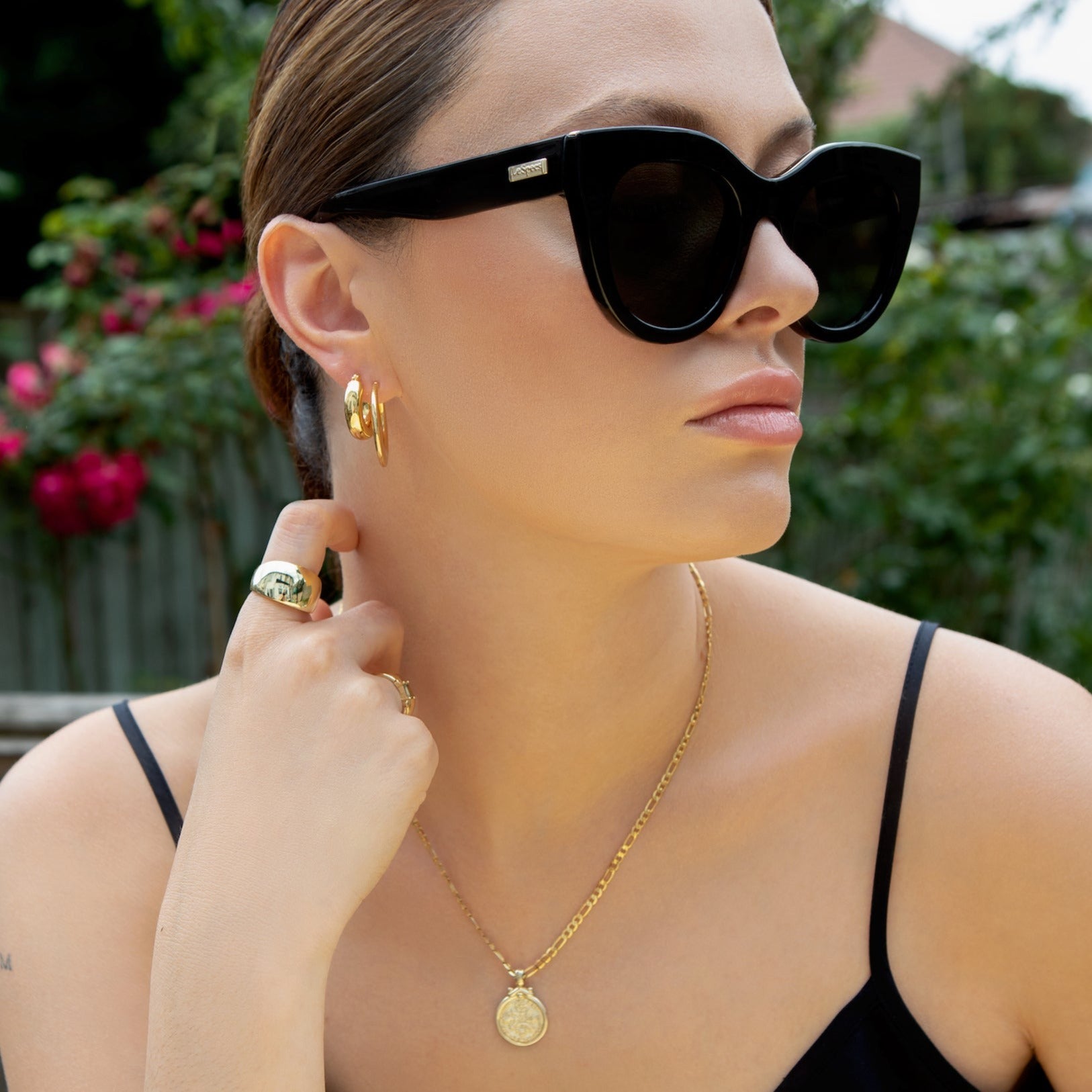 model wears bag hoops paired with chunky medium sized gold hoops