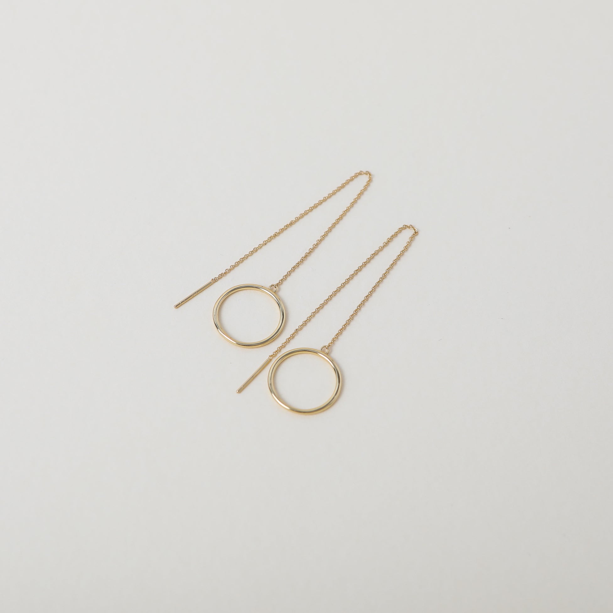 Gold thread through chain earrings featuring small hoop detail
