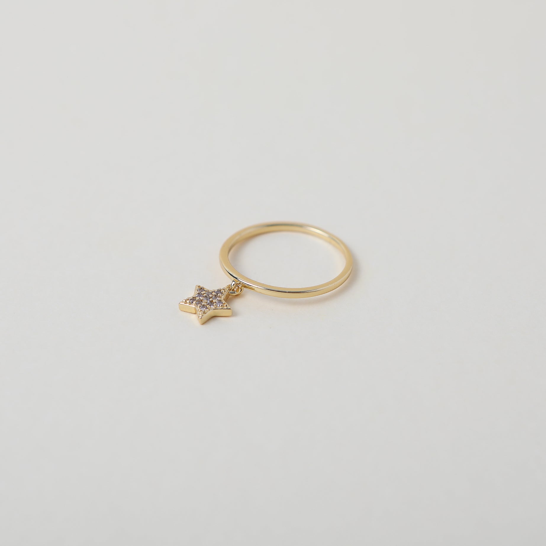 Delicate gold ring with crystal accented star charm