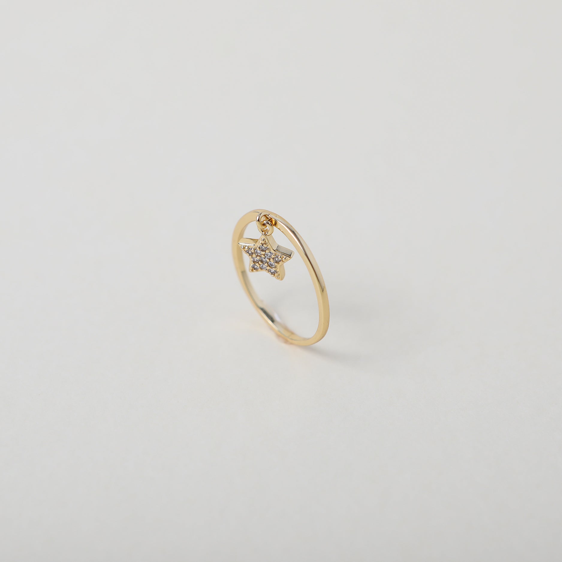 Delicate gold ring with crystal accented star charm