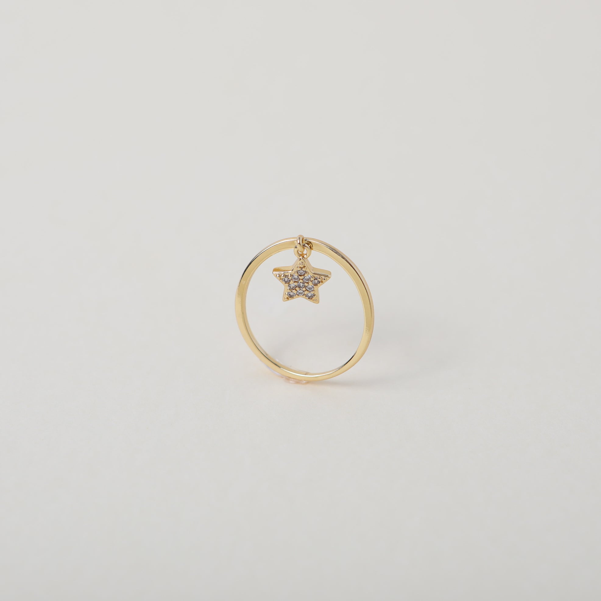 Delicate gold ring with crystal accented star charm