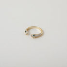 Gold and crystal accented open claw ring featuring two snake heads with green crystal eyes green eyes
