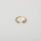 Gold and crystal accented open claw ring featuring two snake heads with green crystal eyes green eyes