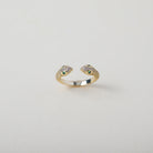 Gold and crystal accented open claw ring featuring two snake heads with green crystal eyes green eyes