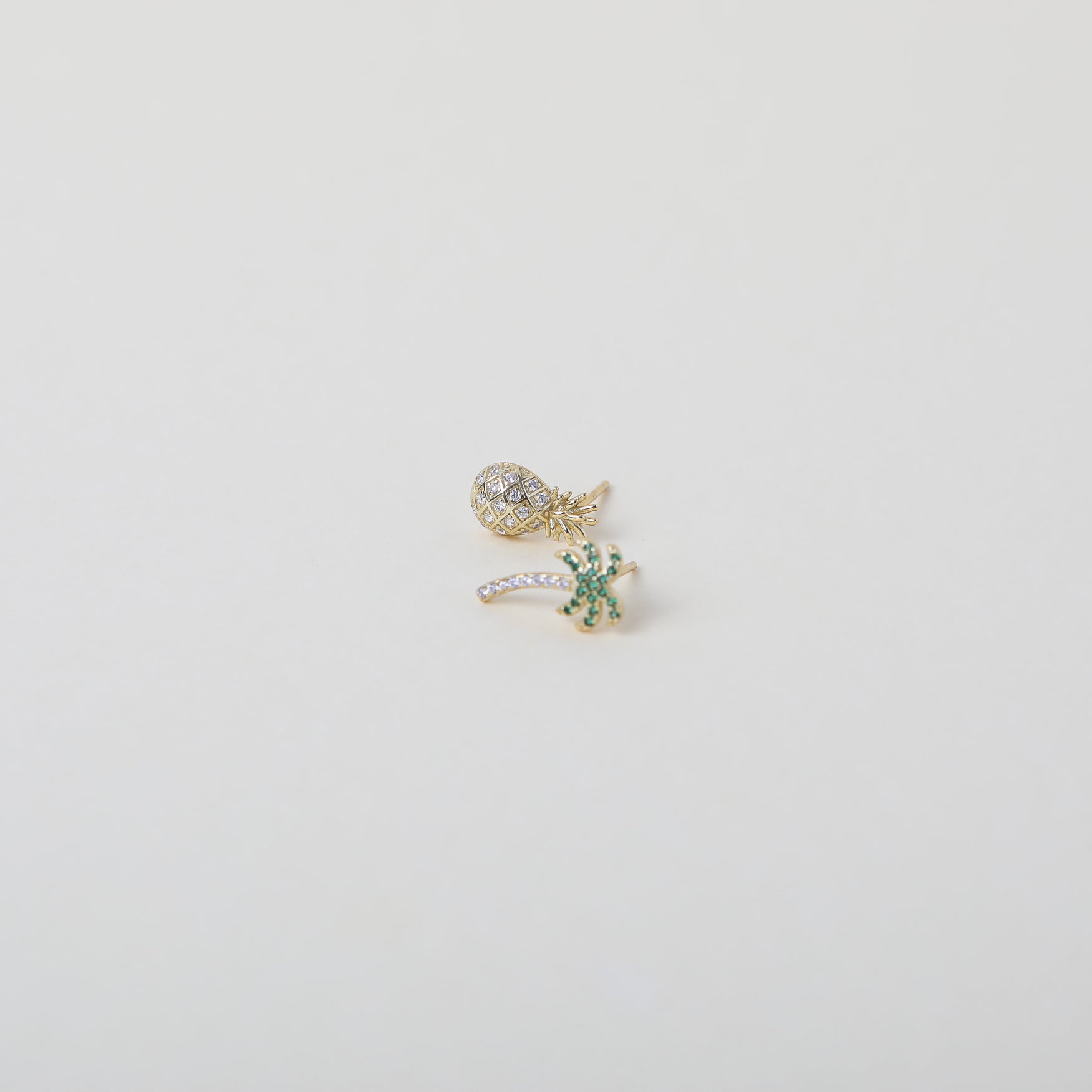 Mismatched gold and green crystal embellished Palm Tree and crystal embellished pineapple duo earring set.