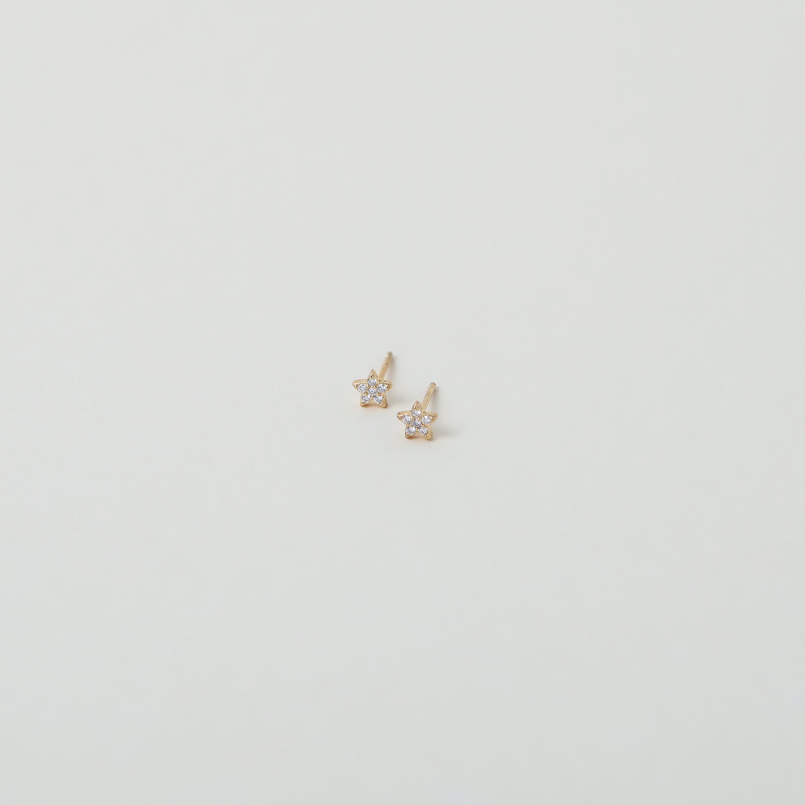 Micro gold star studs with crystal accents
