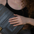 model wearing a square shaped geometric gold and crystal ring