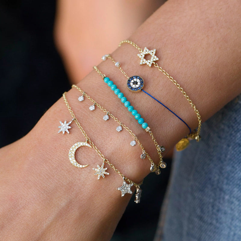 Five crystal embellished moon and star charms on a gold bracelet with lobster clasp closure