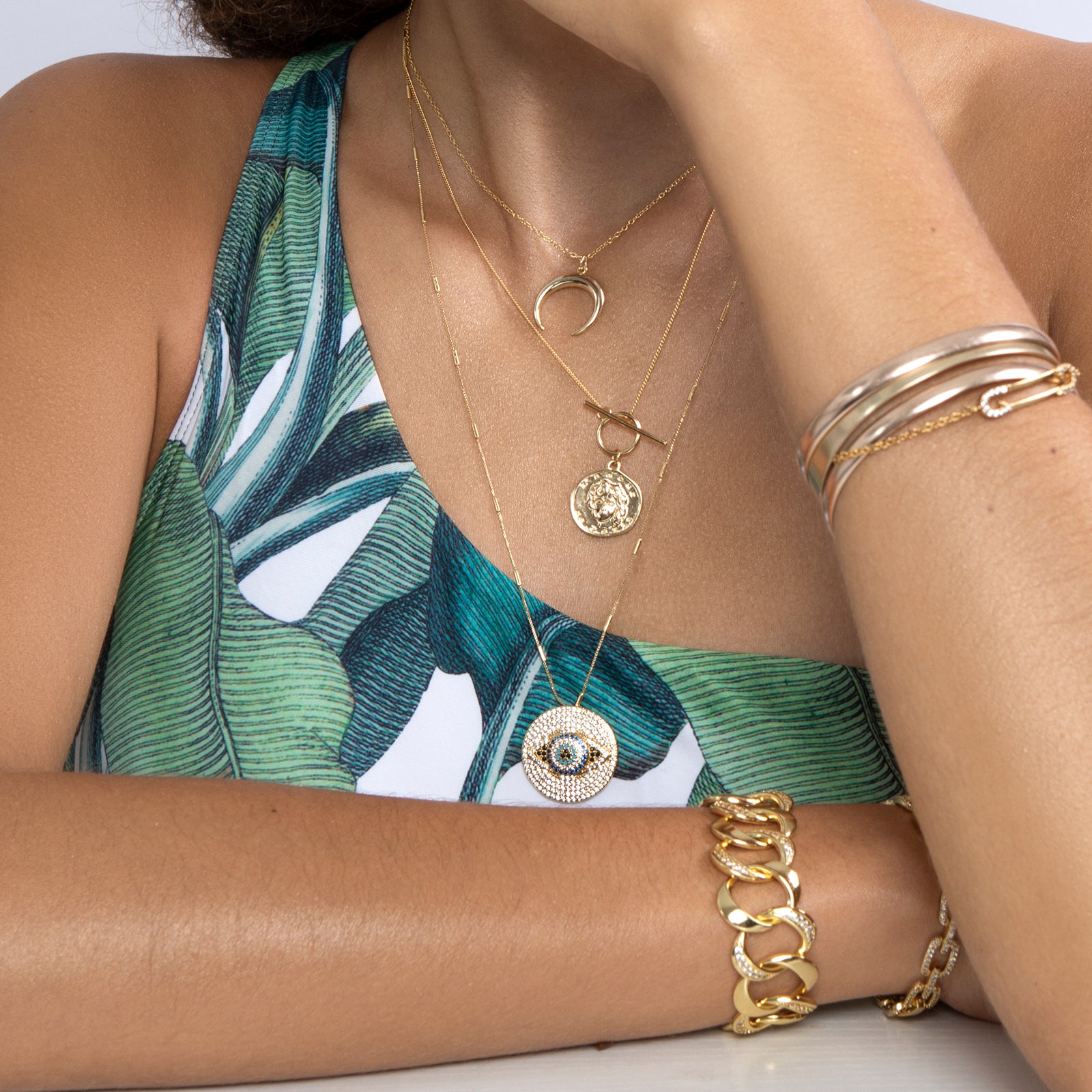 Model wearing crystal accented gold paperclip bracelet