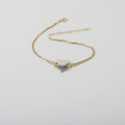Gold twin chain bracelet featuring a smooth gold heart